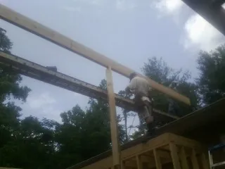 Carpenter setting a ridge beam over a new addition frame — Ice Dam Removal by Roofing Brothers in Lefor