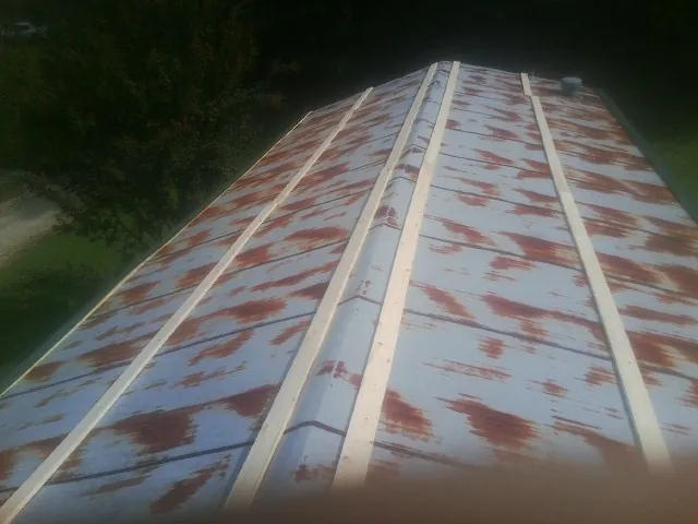 Rusted metal roof panels with new wood purlins before replacement — Storm Damage Roof Repair in Lefor by Roofing Brothers
